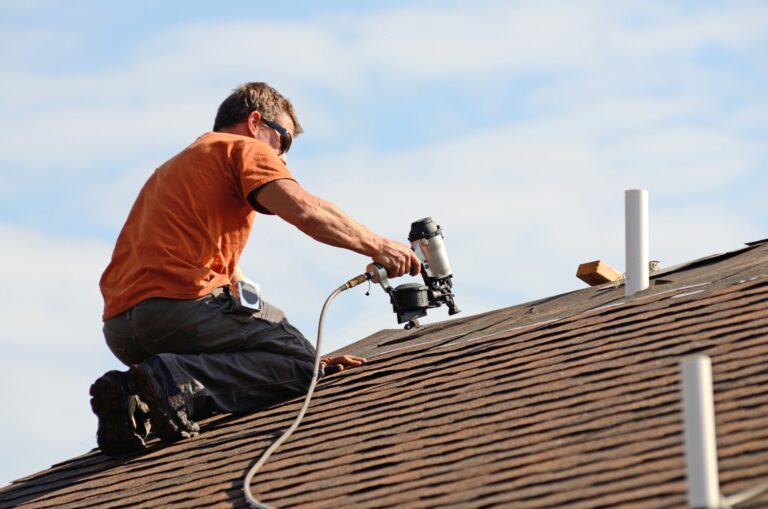 image of a roofer working on a shingle roof